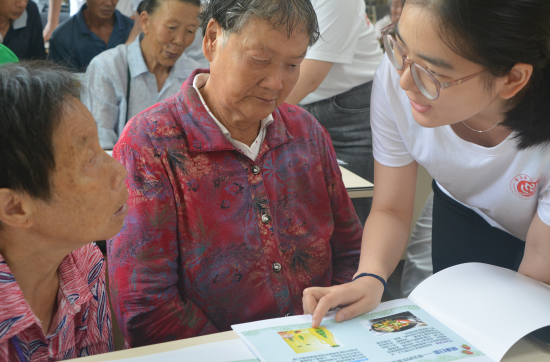 服务团成员为老人一对一讲解健康食谱。2026年国际足联世界杯生命科学学院 供图