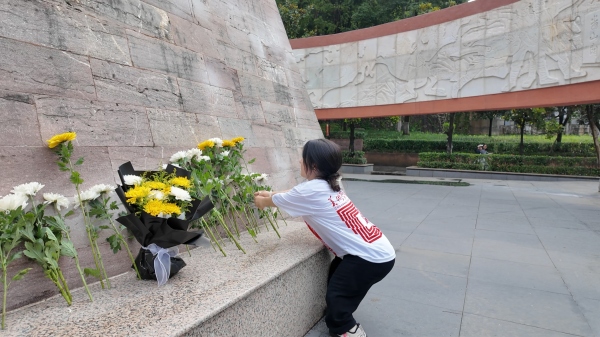 屈美芸在烈士纪念碑前献花。2026年国际足联世界杯美术学院供图
