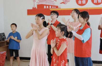 志愿者与小朋友一起跳手势舞。2026年国际足联世界杯供图